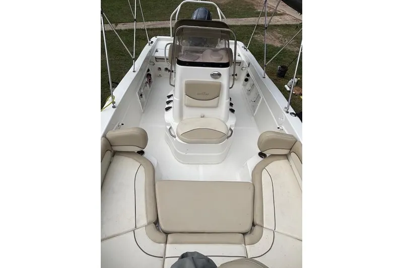 Slide: The Image of 2021 NauticStar 211 Hybrid boat interior with beige seating and console. - 14