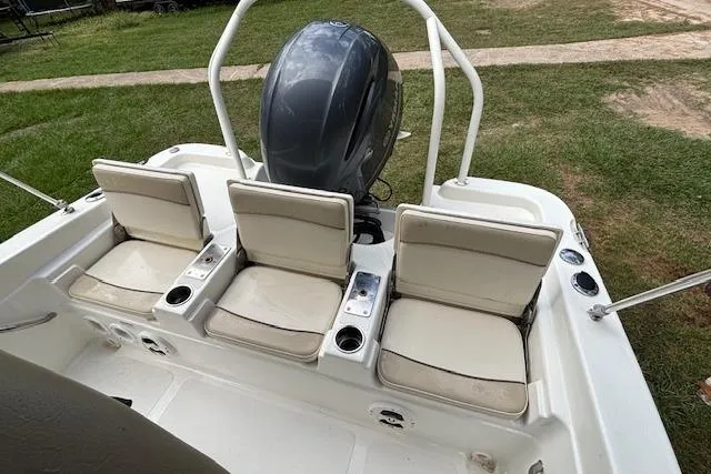 Slide: The Image of 2021 NauticStar 211 Hybrid boat with three cushioned seats and outboard motor. - 5
