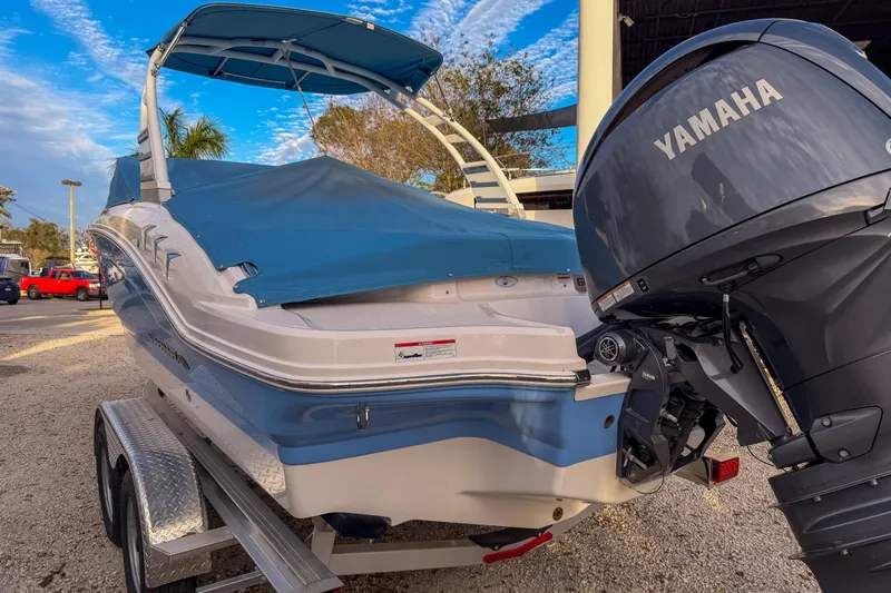 Slide: The Image of 2025 Chaparral 21 SSi OB boat with Yamaha outboard motor, blue cover, on trailer. - 12