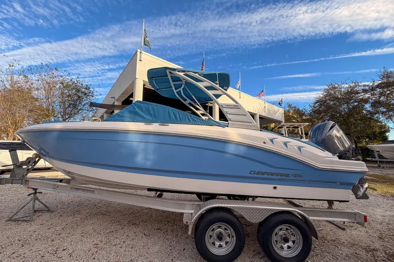 Slide: The Image of 2025 Chaparral 21 SSi OB boat on trailer, blue and white design, outdoor display. - 2
