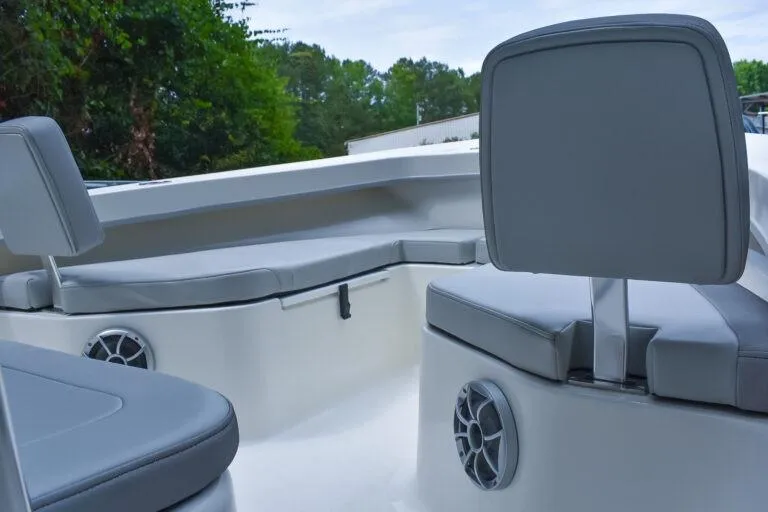 Slide: The Image of 2023 Maycraft 208 boat interior with gray seating and speakers, surrounded by greenery. - 3