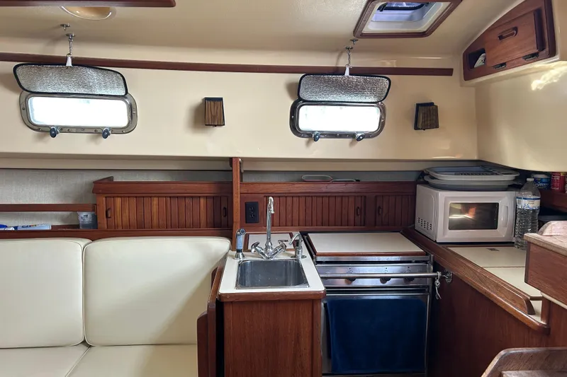 Slide: The Image of 1997 Island Packet 29 yacht interior with kitchenette, sink, and microwave. - 11