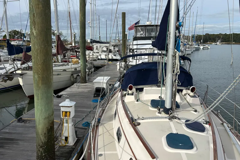 Slide: The Image of 1997 Island Packet 29 sailboat docked at a marina with other boats. - 23