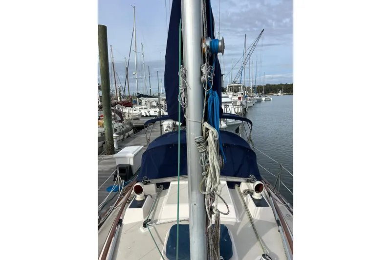 Slide: The Image of 1997 Island Packet 29 sailboat docked at a marina, featuring mast and rigging. - 25