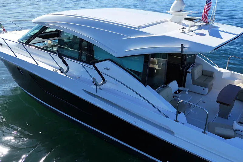 Slide: The Image of 2016 Tiara Yachts 50 Coupe on calm water, showcasing sleek design and spacious deck. - 11