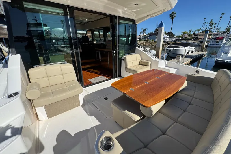 Slide: The Image of 2016 Tiara Yachts 50 Coupe, luxurious outdoor seating and table, marina view. - 12