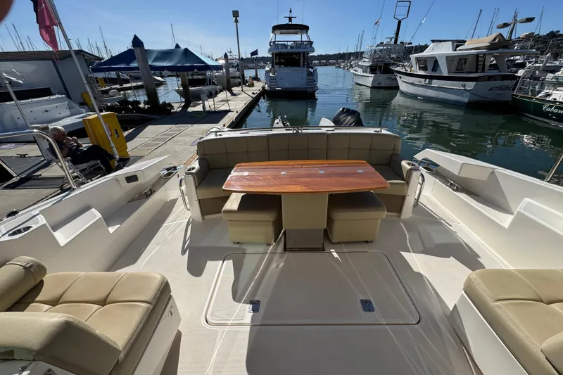 Slide: The Image of 2016 Tiara Yachts 50 Coupe interior with seating and table, docked at marina. - 13