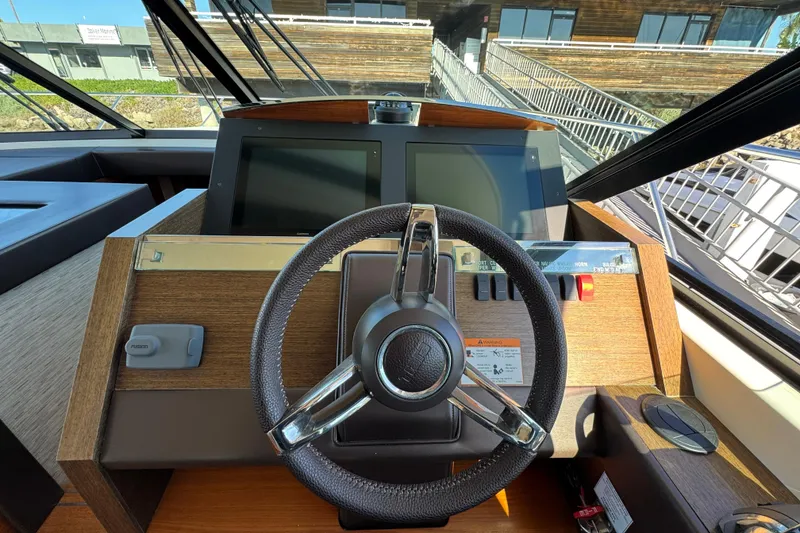 Slide: The Image of Helm of 2016 Tiara Yachts 50 Coupe with modern controls and navigation screens. - 19