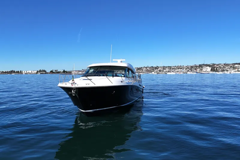Slide: The Image of 2016 Tiara Yachts 50 Coupe on calm blue water, clear sky background. - 2
