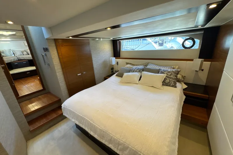 Slide: The Image of Luxurious bedroom interior of 2016 Tiara Yachts 50 Coupe, featuring elegant bedding and wood accents. - 27