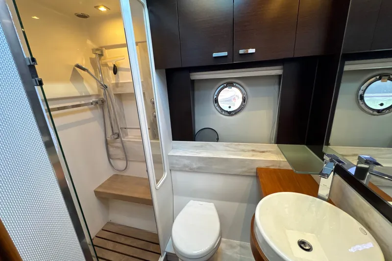 Slide: The Image of Luxurious bathroom in 2016 Tiara Yachts 50 Coupe with modern fixtures and porthole window. - 28