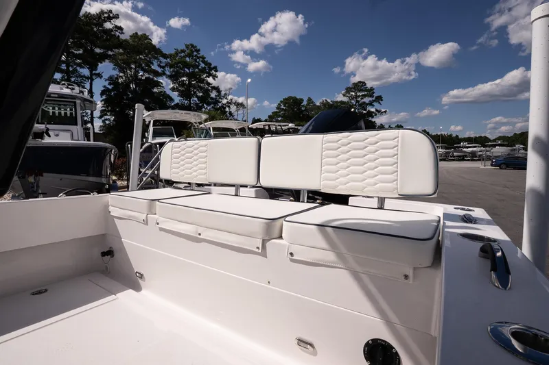 Slide: The Image of 2026 Twin Vee 22 Baycat boat interior with white cushioned seating under a clear blue sky. - 11