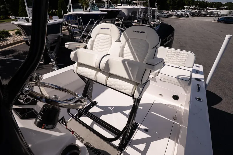 Slide: The Image of 2026 Twin Vee 22 Baycat boat interior with white seating and steering wheel. - 16