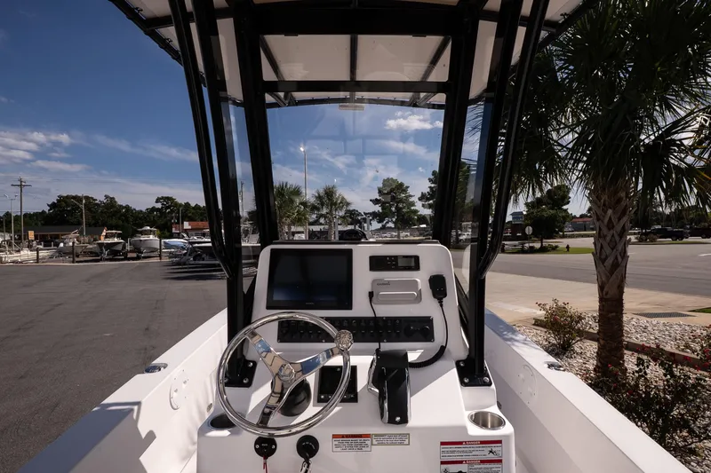Slide: The Image of 2026 Twin Vee 22 Baycat boat dashboard with steering wheel and navigation controls. - 18