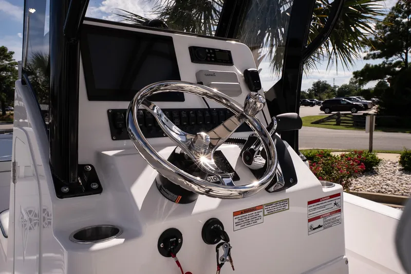 Slide: The Image of Steering console of 2026 Twin Vee 22 Baycat boat with modern controls and display. - 19