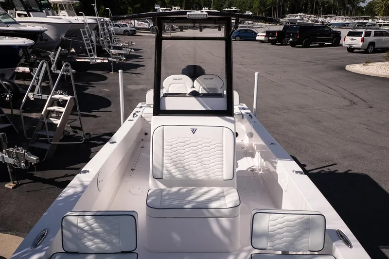 Slide: The Image of 2026 Twin Vee 22 Baycat boat with white seating, displayed at a marina. - 26