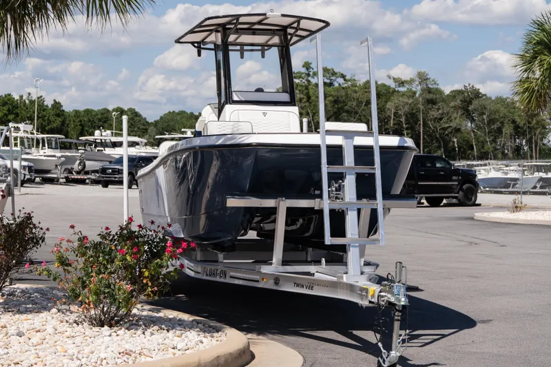 Slide: The Image of 2026 Twin Vee 22 Baycat boat on trailer, parked outdoors under a sunny sky. - 5