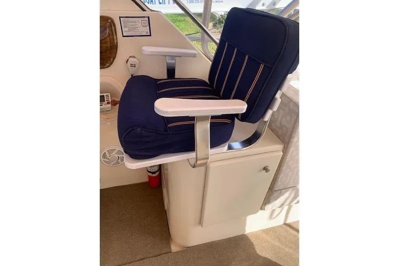Slide: The Image of Captain's chair on 2004 Mainship Pilot 30-II boat, featuring blue cushioned seating. - 10