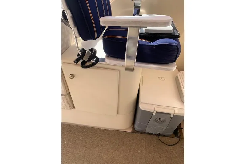 Slide: The Image of 2004 Mainship Pilot 30-II interior with blue cushioned seat and storage compartment. - 11