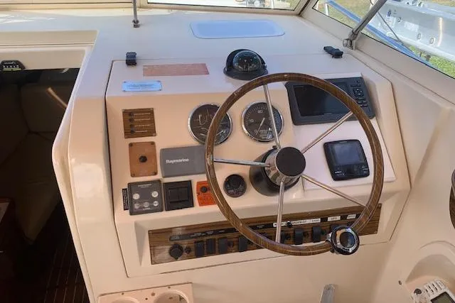 Slide: The Image of 2004 Mainship Pilot 30-II helm with steering wheel and navigation instruments. - 12