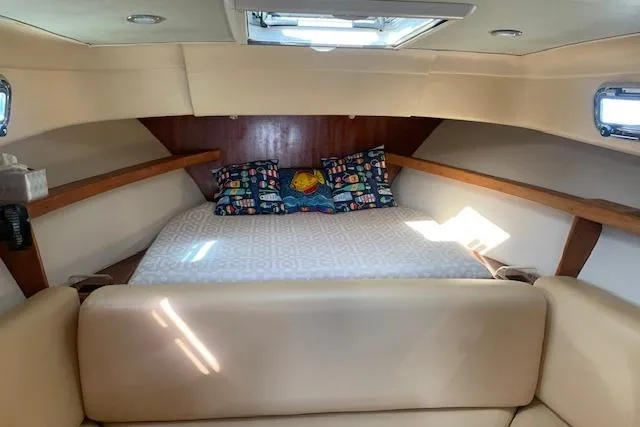 Slide: The Image of 2004 Mainship Pilot 30-II cabin interior with bed, colorful pillows, and natural light. - 15