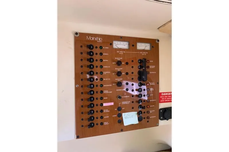 Slide: The Image of Electrical control panel of 2004 Mainship Pilot 30-II boat with various switches and meters. - 16