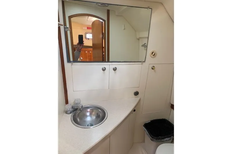 Slide: The Image of 2004 Mainship Pilot 30-II bathroom with sink, mirror, and storage cabinets. - 17
