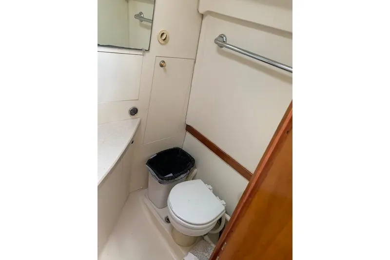 Slide: The Image of 2004 Mainship Pilot 30-II boat bathroom with toilet and trash bin. - 18