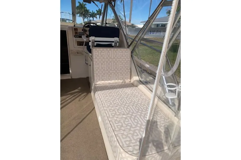 Slide: The Image of 2004 Mainship Pilot 30-II interior with patterned seating and helm station. - 8