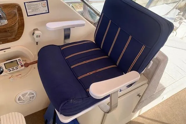 Slide: The Image of Blue captain's chair on 2004 Mainship Pilot 30-II boat, featuring striped upholstery and armrests. - 9