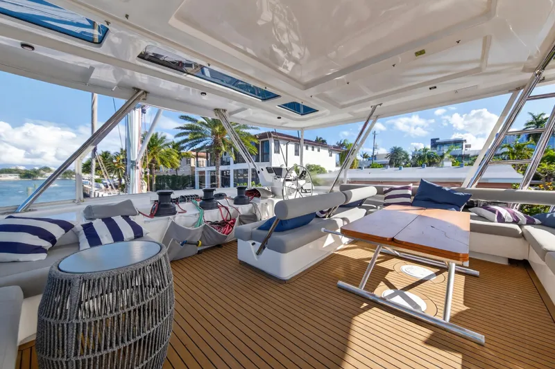 Slide: The Image of Luxurious 2019 Leopard 58 yacht interior with spacious seating, wooden deck, and scenic waterfront view. - 18