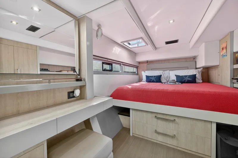 Slide: The Image of Luxurious 2019 Leopard 58 yacht bedroom with red bedding and modern wood accents. - 26