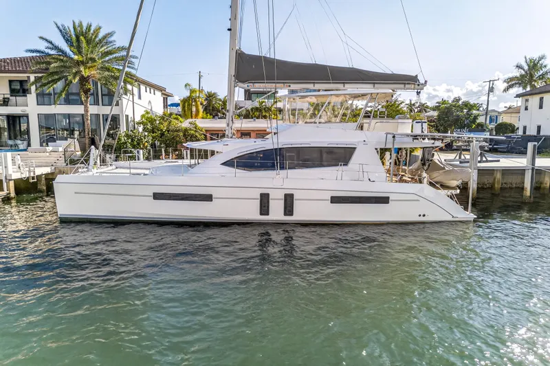 Slide: The Image of 2019 Leopard 58 catamaran docked by waterfront homes, showcasing sleek design and modern features. - 34