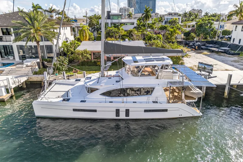 Slide: The Image of 2019 Leopard 58 catamaran docked in a sunny marina, surrounded by lush greenery. - 35