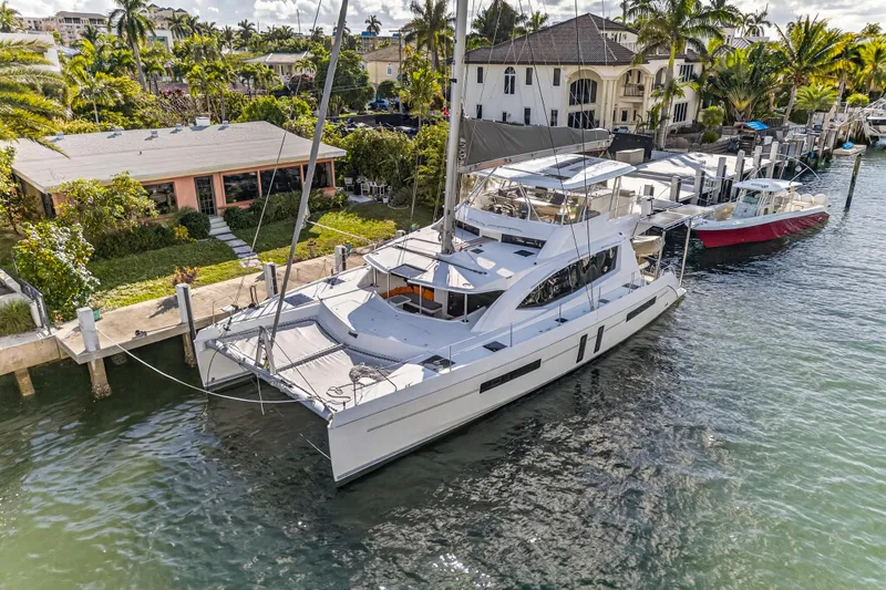 Slide: The Image of 2019 Leopard 58 catamaran docked by waterfront homes, surrounded by lush greenery. - 37