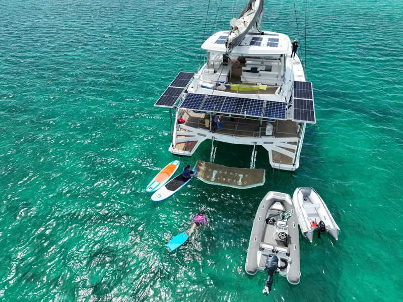 Slide: The Image of 2019 Leopard 58 yacht with paddleboards and dinghy in turquoise water. - 38