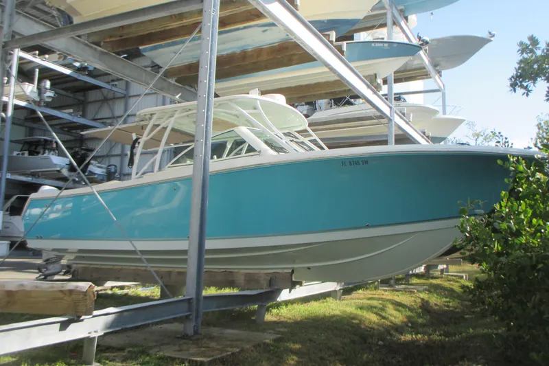 The Image of 2019 Sailfish 325 DC boat on trailer, parked outdoors with palm trees. - 0