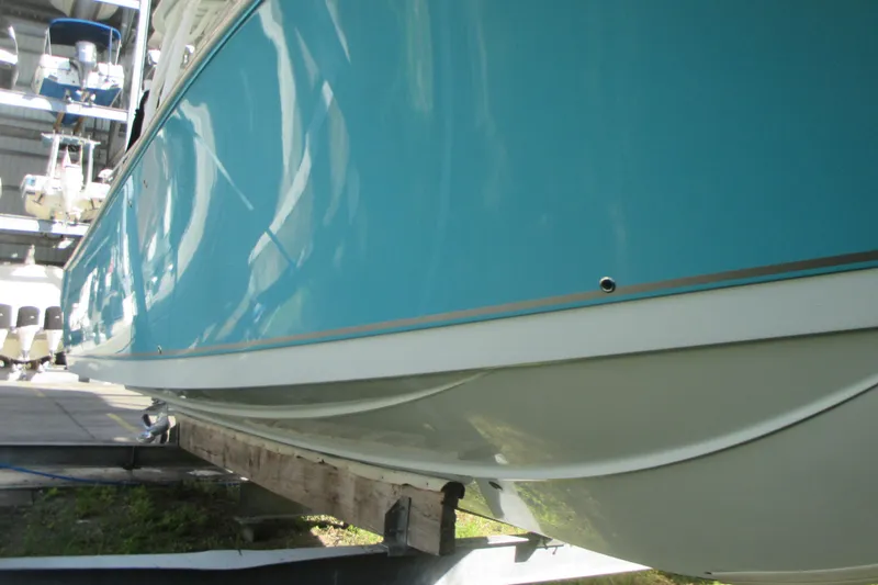 Slide: The Image of 2019 Sailfish 325 DC boat on trailer, blue hull, Mercury outboard, waterfront background. - 3
