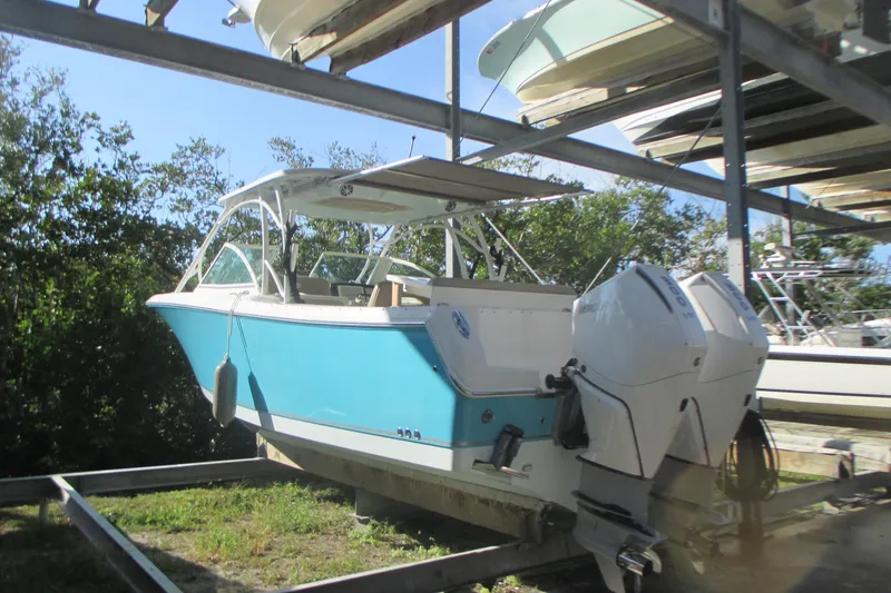 Slide: The Image of 2019 Sailfish 325 DC boat in dry storage, featuring a sleek blue hull. - 6