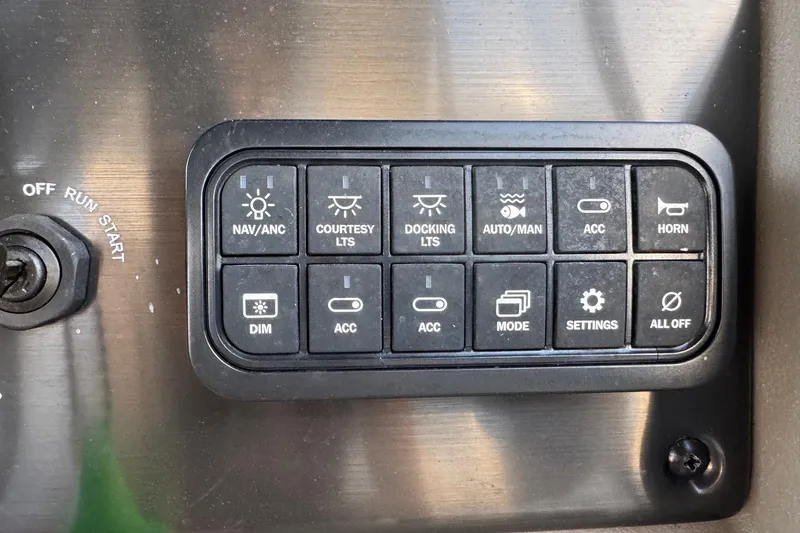 Slide: The Image of Control panel of 2024 Sun Tracker SportFish 20 DLX with various switches and settings. - 11