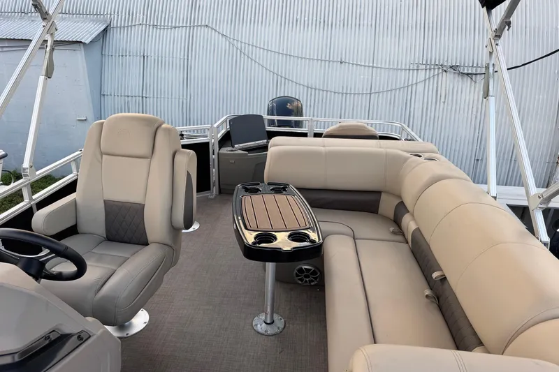 Slide: The Image of 2024 Sun Tracker SportFish 20 DLX pontoon boat interior with beige seating and table. - 13