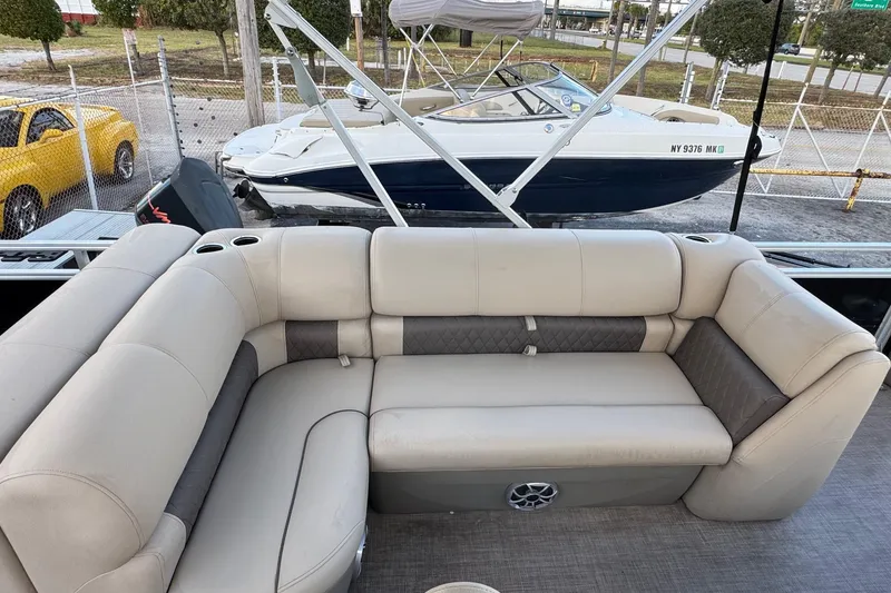 Slide: The Image of 2024 Sun Tracker SportFish 20 DLX pontoon boat with beige seating and cup holders. - 14