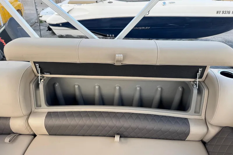 Slide: The Image of 2024 Sun Tracker SportFish 20 DLX boat seat storage compartment, open with cup holders. - 20