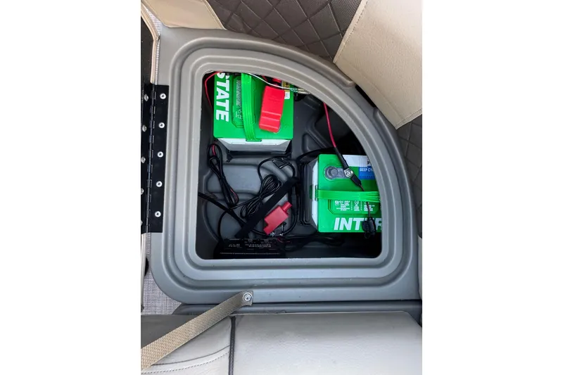 Slide: The Image of 2024 Sun Tracker SportFish 20 DLX battery compartment with wiring and green batteries. - 23