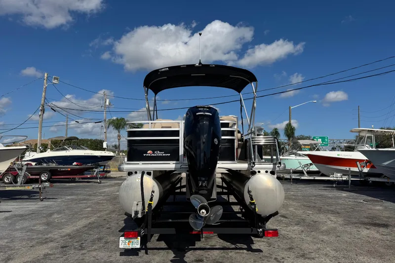 Slide: The Image of 2024 Sun Tracker SportFish 20 DLX pontoon boat in a marina under a clear blue sky. - 3