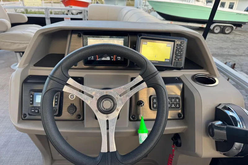 Slide: The Image of 2024 Sun Tracker SportFish 20 DLX dashboard with steering wheel and navigation controls. - 6