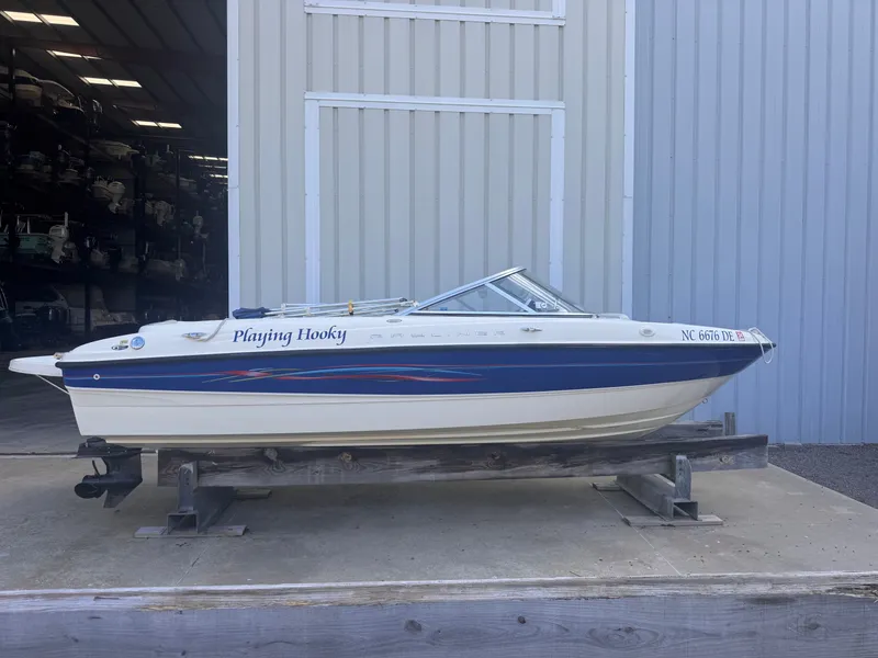 The Image of 2006 Bayliner 185 boat on a stand outside a warehouse. - 0