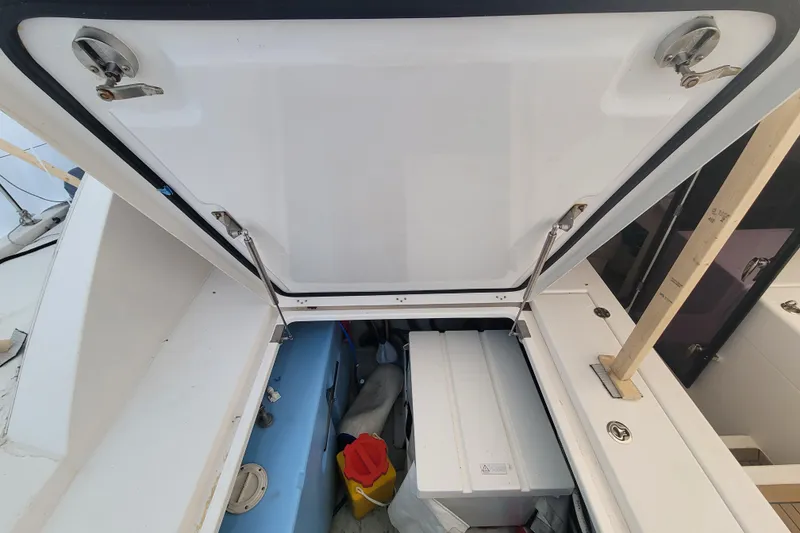 Slide: The Image of Open storage compartment on 2018 Leopard 40 boat, revealing equipment and supplies. - 34