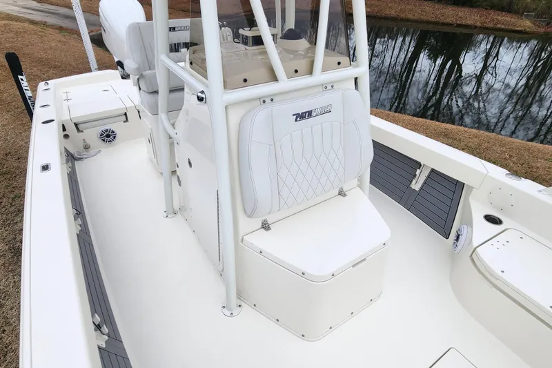 Slide: The Image of 2024 Pathfinder 2600 TRS boat interior with seating and console, near a calm water body. - 10