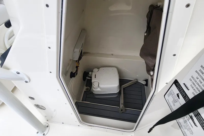 Slide: The Image of 2024 Pathfinder 2600 TRS boat interior storage compartment with portable toilet. - 11